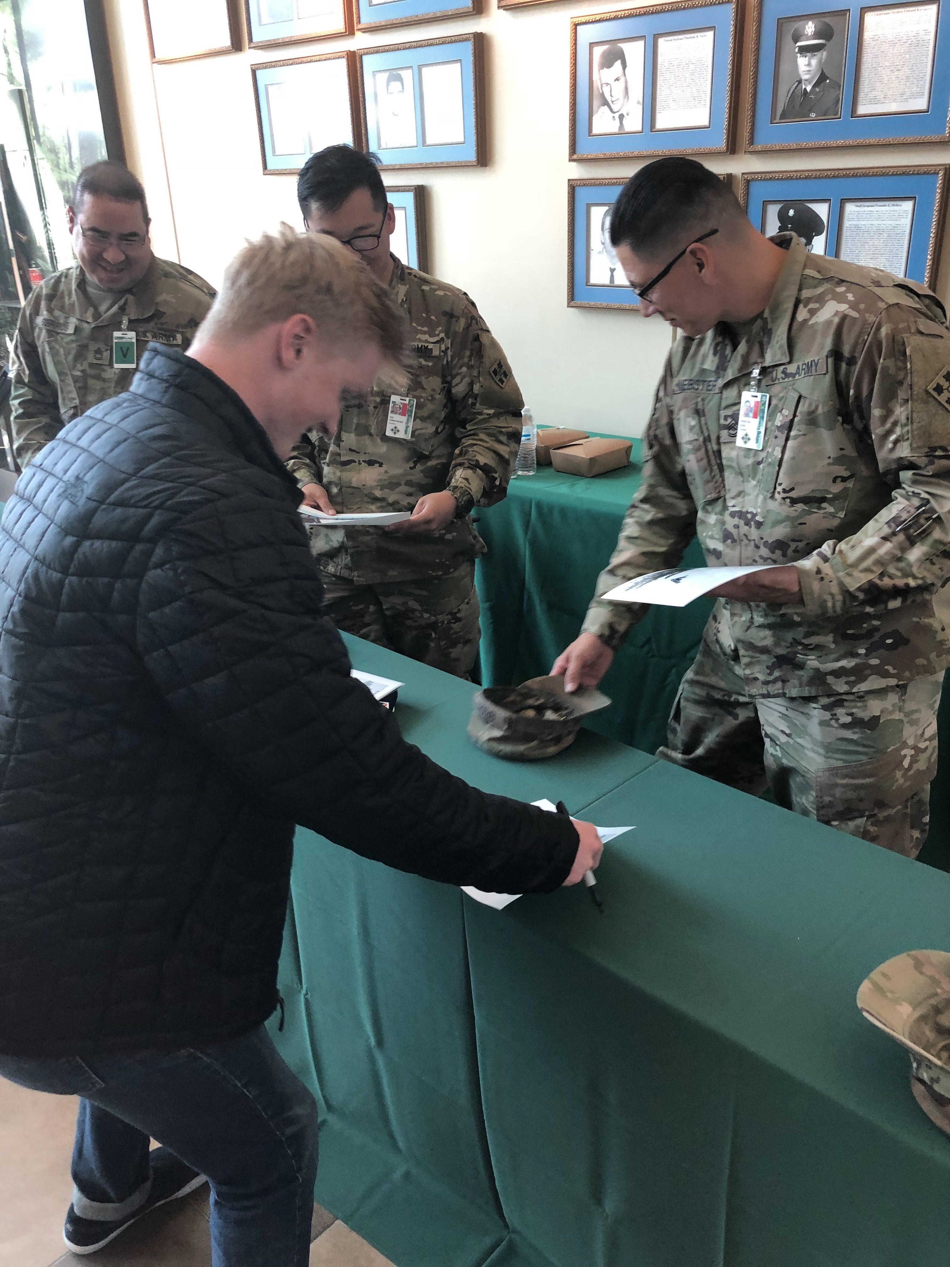 Jason Wolle signing posters at Fort Carson for the soldiers