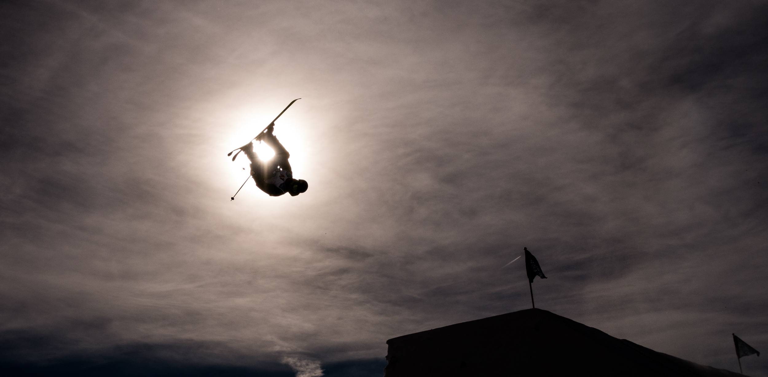Athlete mid air in front of the sun in Stubai, Austria.